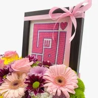 تنسيق زهور مع  إطار بتطريز كلمة "أمي" باللون الوردي 