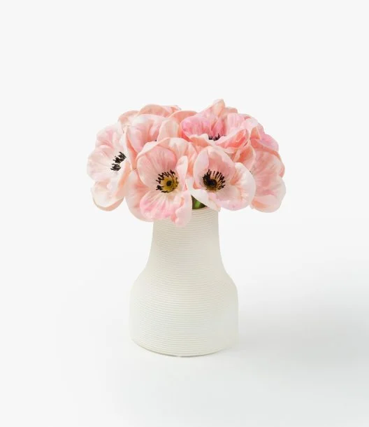 تشكيلة زهور صغيرة من زهور الخشخاش الوردية في مزهرية خزفية