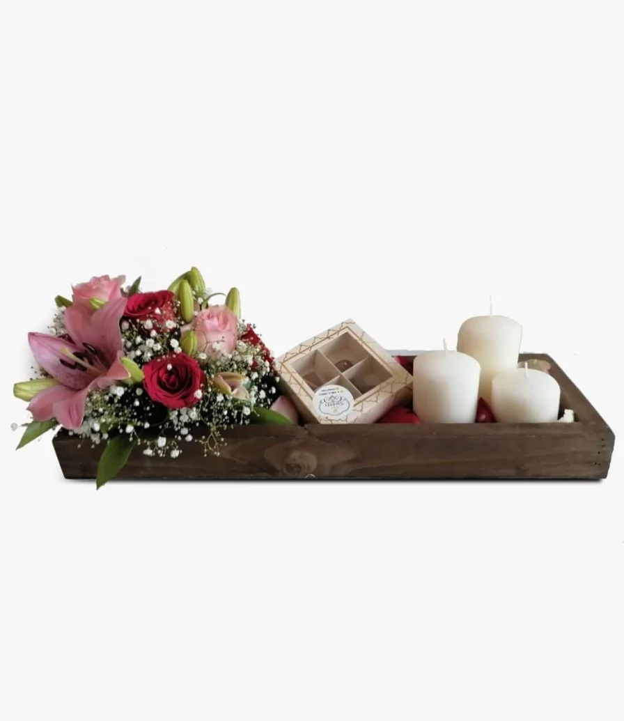 مجموعة زهور وشوكولاتة وشموع داخل صينية خشبية