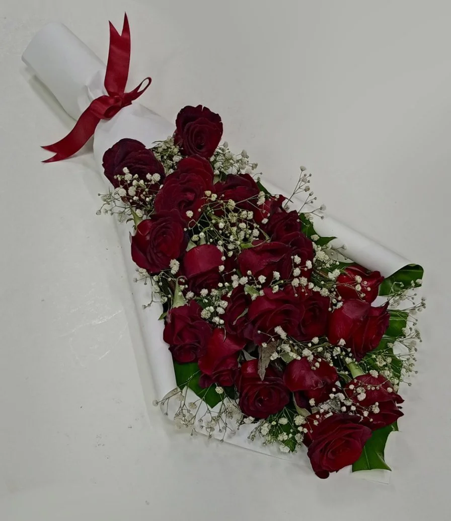 باقة من الورود الحمراء في غلاف من الورق الأبيض