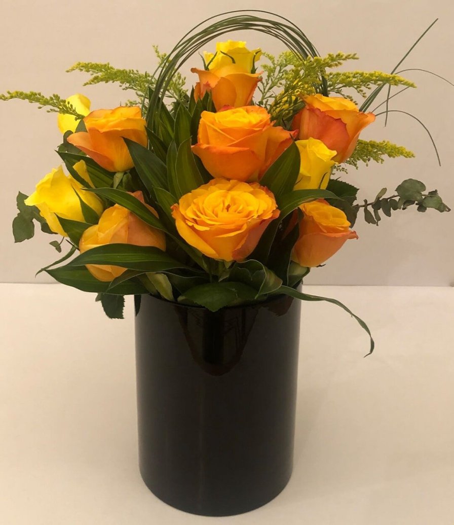 Yellow roses in a black vase arrangement